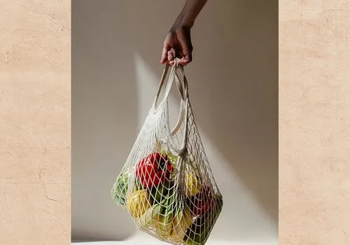 Woman holding shopping bag of fruits and veggies