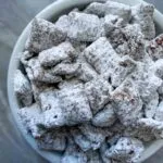 This is chex mix puppy chow. There is chex cereal coated with peanut butter and chocolate, along with white powdered sugar.